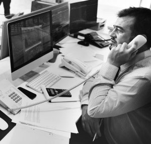 Share trader in front of screen with telephone